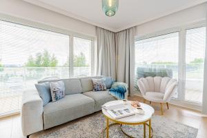 a living room with a couch and a table at Apartamenty Tukan- Polanki Aqua - Holiday City in Kołobrzeg