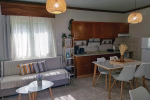 a living room with a couch and a table and a kitchen at Nikis House in Keramoti