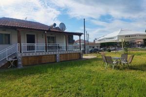 a house with a table and chairs in the yard at Nikis House in Keramoti