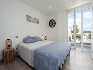 a white bedroom with a bed and a large window at Villa Marina N173 - 5P6 in Le Grau-du-Roi