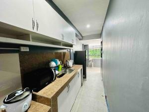 a kitchen with a counter and a sink and a refrigerator at Rai Staycation in Sampong +18 photos