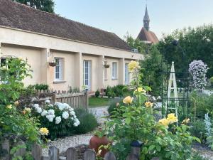 a garden in front of a house with flowers at Riverside Lodge in Chablis