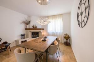 a dining room with a table and chairs and a clock at Villa Artea in Podstrana