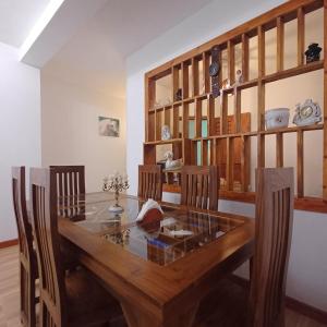 a dining room with a wooden table and chairs at Cloudberry Inn Vibe in Nuwara Eliya