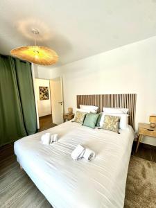 a bedroom with a large bed with white sheets and pillows at T2 confort - résidence privée in Propriano