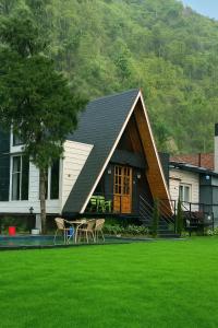 デヘラードゥーンにあるThe Brookside Bungalowの庭のテーブルと椅子付きの家