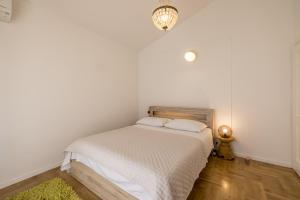 a bedroom with a bed with white sheets and a lamp at Villa Artea in Podstrana +52 photos