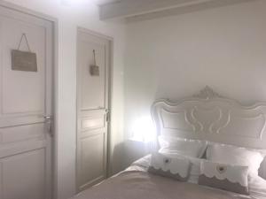 una camera bianca con letto e testiera bianca di Chambre du Rouard LE RUISSEAU a Camiers
