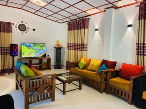a living room with two couches and a tv at Madiriya Forest Lodge Apartment in Badulla
