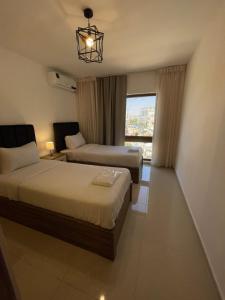 a hotel room with two beds and a window at 2bedroom aprt at 7th circle f-r4 in Amman +31 photos