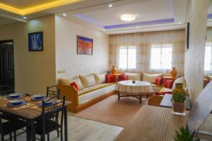 a living room with a couch and a table at Fabuleux Appartement bien équipé à Agadir in Agadir