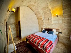 a bedroom with a bed in a stone wall at Evra Cappadocia Hotel in Nevşehir