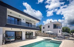 a villa with a swimming pool and a house at Villa Aura by Villas Guide in Urinj