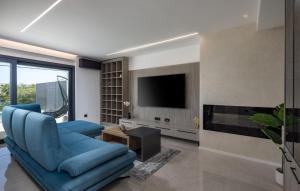 a living room with a blue couch and a tv at Villa Aura by Villas Guide in Urinj