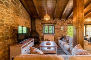 ein Wohnzimmer mit Sofa und Tisch in der Unterkunft Cabaña Pasiega El Ojal in San Pedro del Romeral