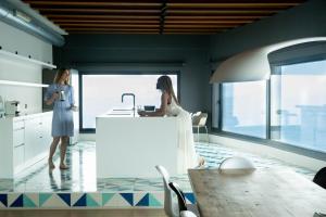 two women standing in a kitchen with a sink at BYPILLOW Cap Sa Sal in Begur