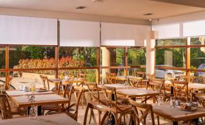 un restaurante con mesas y sillas de madera y ventanas en Hotel Estel, en Berga 26 fotos más