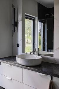 two sinks in a bathroom with two mirrors at Glow Apartments - Dom Ostoja Rekownica, Kaszuby na 10 osób z sauną i balią in Będomin +93 photos