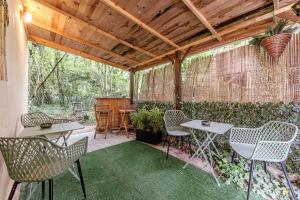 a patio with chairs and tables and a fence at Gîte zen dans les bois in Blésignac