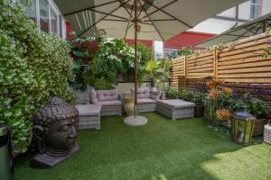 un giardino con una statua di una testa e un ombrello di Hotel Ristorante Ala d'Oro a Lugo