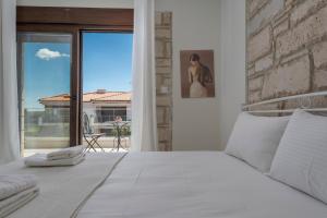 a bedroom with a white bed and a large window at White Pearl Collection in Flogita