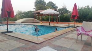 2 personas en una piscina con cenador en Spacious Garden Villa, private pool, huge grounds with orange trees, en Dos Hermanas