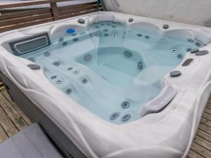 eine Whirlpool-Badewanne auf einem Holzboden in der Unterkunft Holiday Home Villa kaarina by Interhome in Lohja