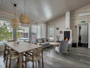 ein Wohnzimmer mit einem Esstisch und einem Kamin in der Unterkunft Holiday Home Villa kaarina by Interhome in Lohja
