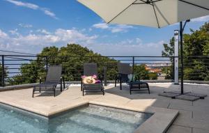 a patio with chairs and an umbrella and a pool at Villa Aris by Villas Guide in Urinj
