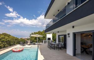a house with a swimming pool and a patio at Villa Aris by Villas Guide in Urinj