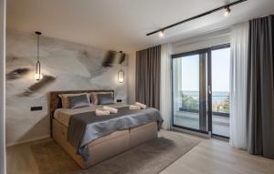 a bedroom with a large bed and a large window at Villa Aris by Villas Guide in Urinj +13 photos