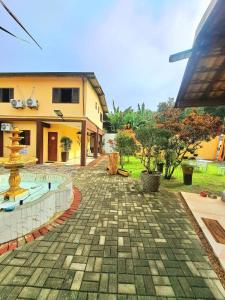 a courtyard with a fountain in front of a building at Refugio Prumirim Camping in Ubatuba