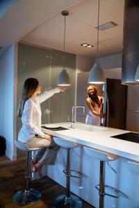 a woman in a kitchen looking in a mirror at BYPILLOW Cap Sa Sal in Begur