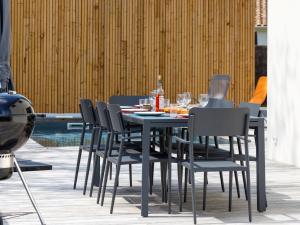 a table and chairs with drinks and wine bottles on it at Holiday Home Le Pré Tarin by Interhome in La Bernerie-en-Retz