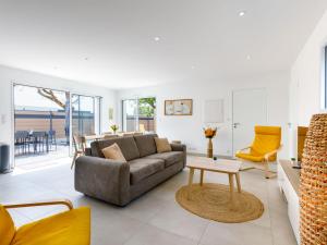 a living room with a couch and a table at Holiday Home Le Pré Tarin by Interhome in La Bernerie-en-Retz