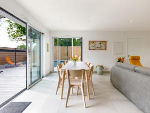 a dining room with a table and a couch at Holiday Home Le Pré Tarin by Interhome in La Bernerie-en-Retz