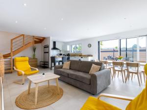 a living room with a couch and a table at Holiday Home Le Pré Tarin by Interhome in La Bernerie-en-Retz