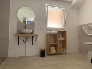 a bathroom with a sink and a mirror at L'étape de Marcel - Aymé in Avoine