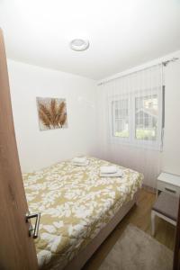 a bedroom with a bed and a window at NeVa Apartman in Rakari