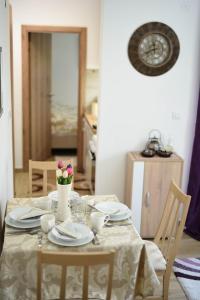 a dining room table with plates and flowers on it at NeVa Apartman, Banja Vrujci in Rakari +10 photos