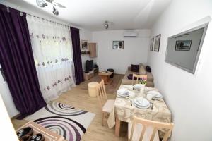 a living room with a table and a dining room at NeVa Apartman, Banja Vrujci in Rakari