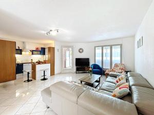 a living room with a couch and a kitchen at Holiday Home Maison Valoma by Interhome in Lunel