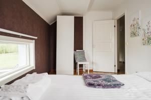 a bedroom with a bed and a window and a chair at Guestly Homes - 3BR Spacious Coastal Stay in Luleå