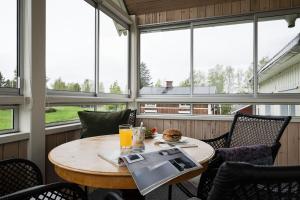 a table in a screened in porch with windows at Guestly Homes - 3BR Spacious Coastal Stay in Luleå