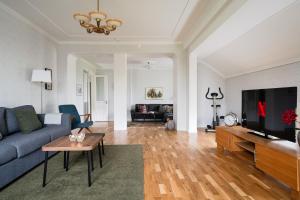 a living room with a blue couch and a tv at Guestly Homes - 3BR Spacious Coastal Stay in Luleå