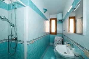 a blue bathroom with a shower and a sink at CasaVacanzeAurora in San Vito lo Capo +34 photos