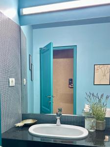 a bathroom with a sink and a blue wall at La Vista by Ronda in Eforie Sud