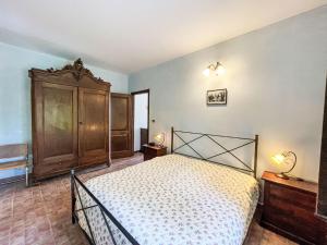 a bedroom with a bed and a wooden cabinet at Apartment Cà Maria-1 by Interhome in Asti