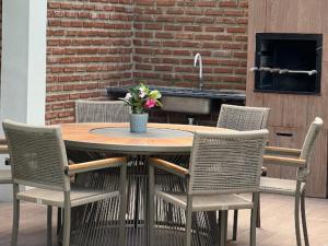 a wooden table with chairs and a table with flowers on it at Bangalôs de Peroba in Maragogi
