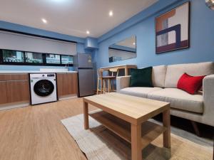 een woonkamer met een bank en een tafel bij BEB Silom Condolette in Bangkok